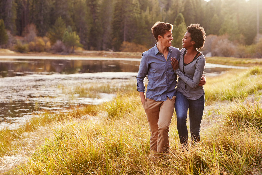 Mixed Race Couple Embracing, Walking near a Rural Lake